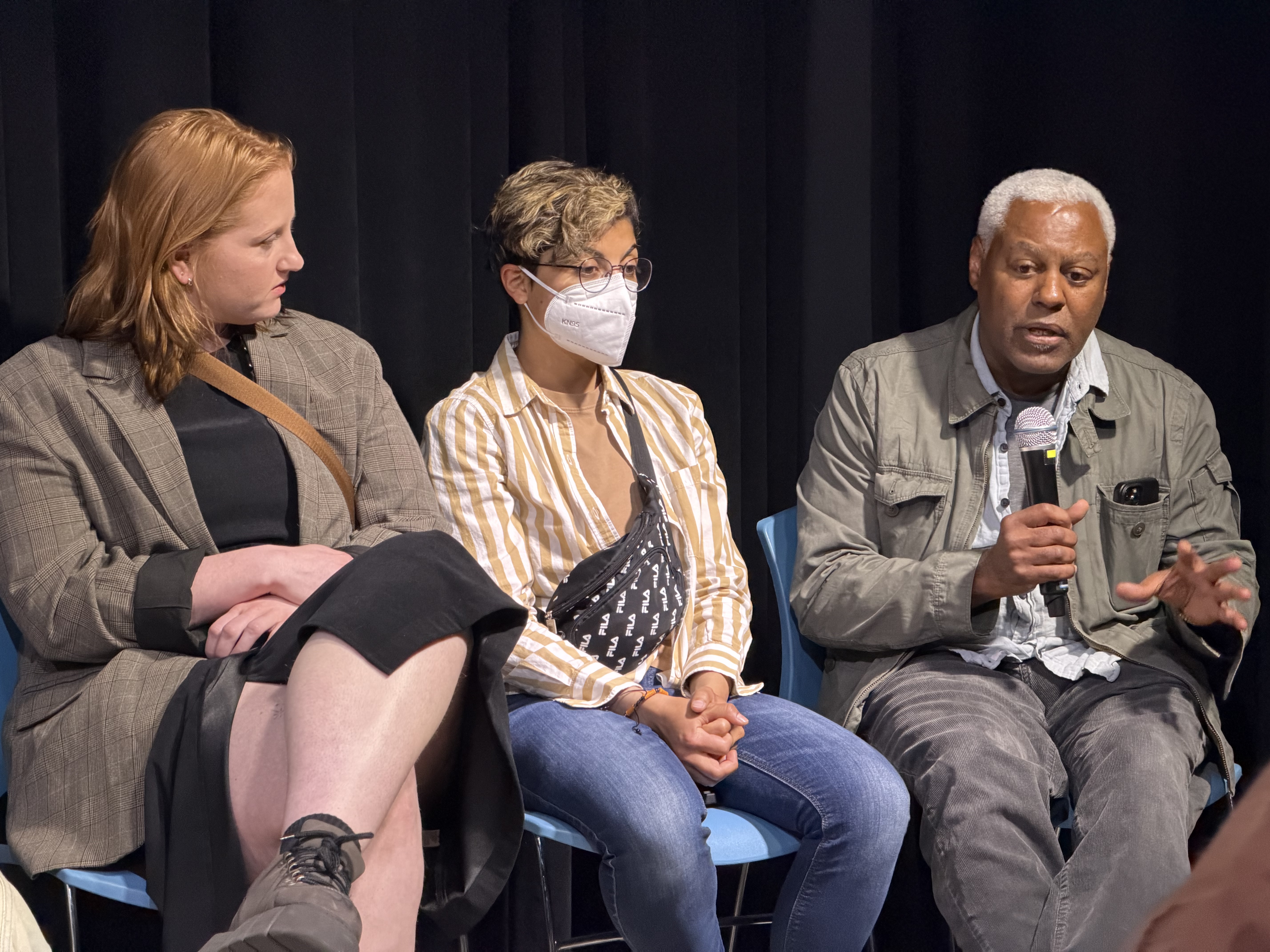 three individuals seated in separate chairs during the filmmaker question and answer portion of the screening event. 